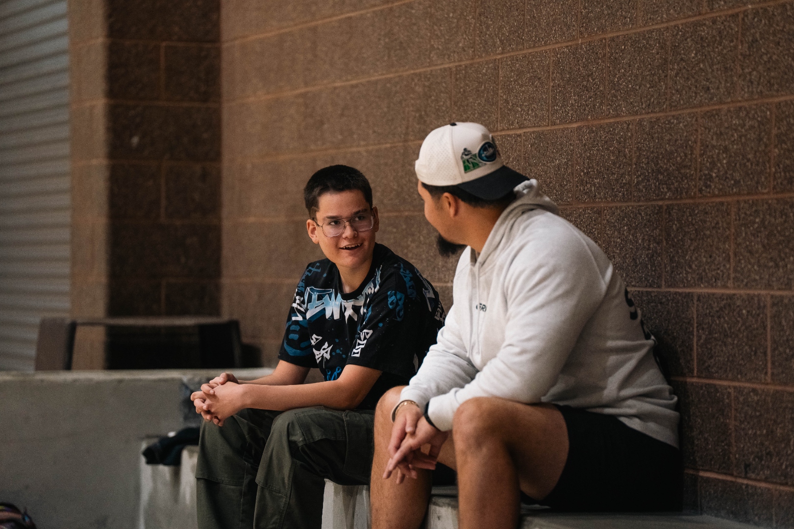 FaleOfaz staff member in deep one-on-one conversation with a client outside