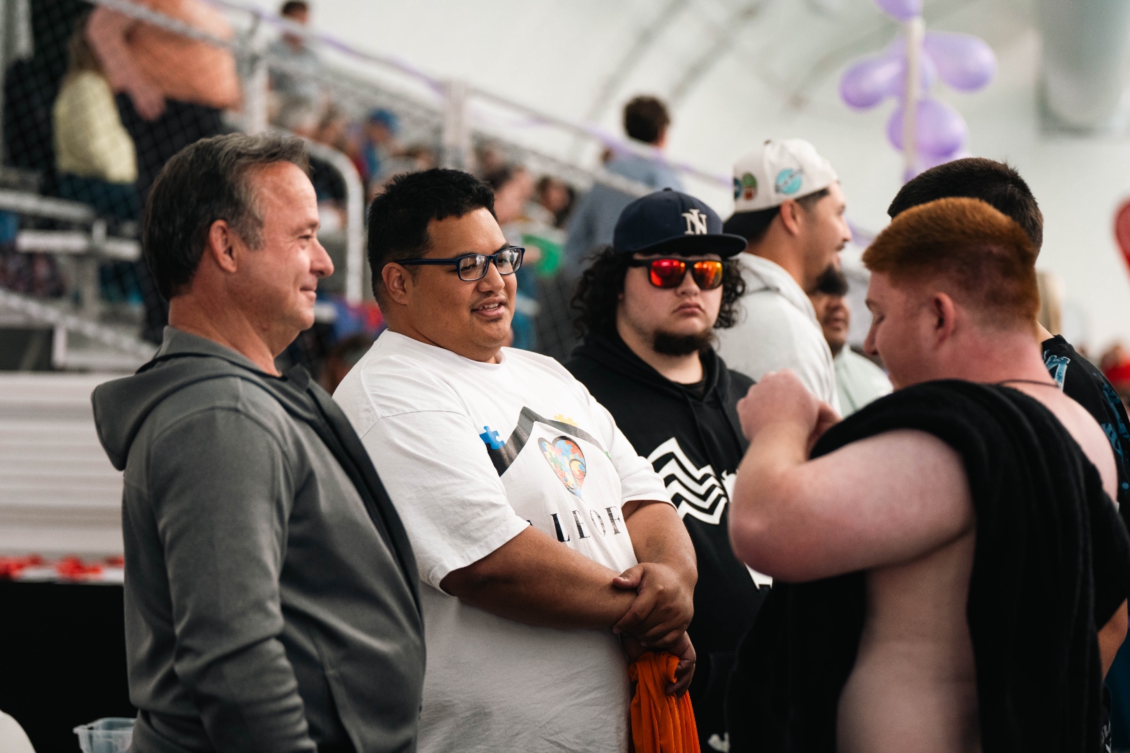 FaleOfaz staff in logo shirt talking and laughing with clients at the swim meet